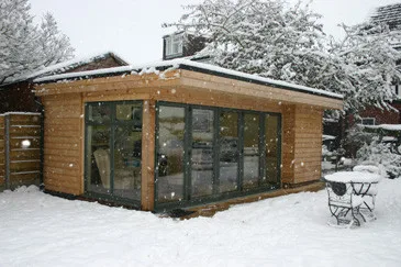 Cladded garden room with bi-fold doors in the snow